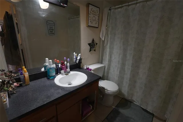 a bathroom with a sink vanity mirror and toilet