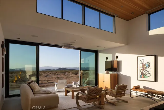 a living room with furniture a floor to ceiling window and a flat screen tv