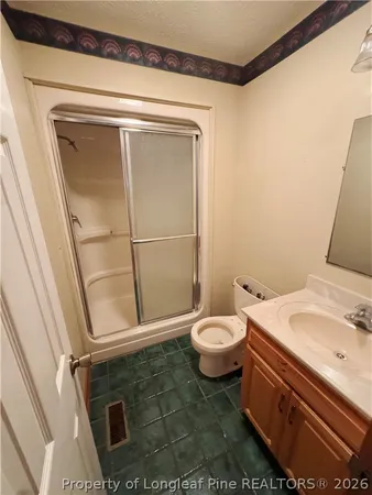 a bathroom with a granite countertop sink mirror vanity and toilet