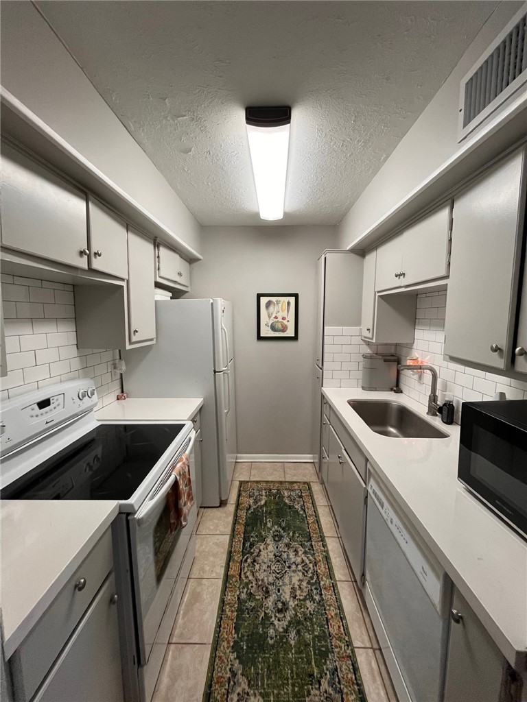 4441 Old College Road, Unit 5204 Bryan, TX 77801 - Photo 4 of 14 a kitchen with a sink and a stove top oven