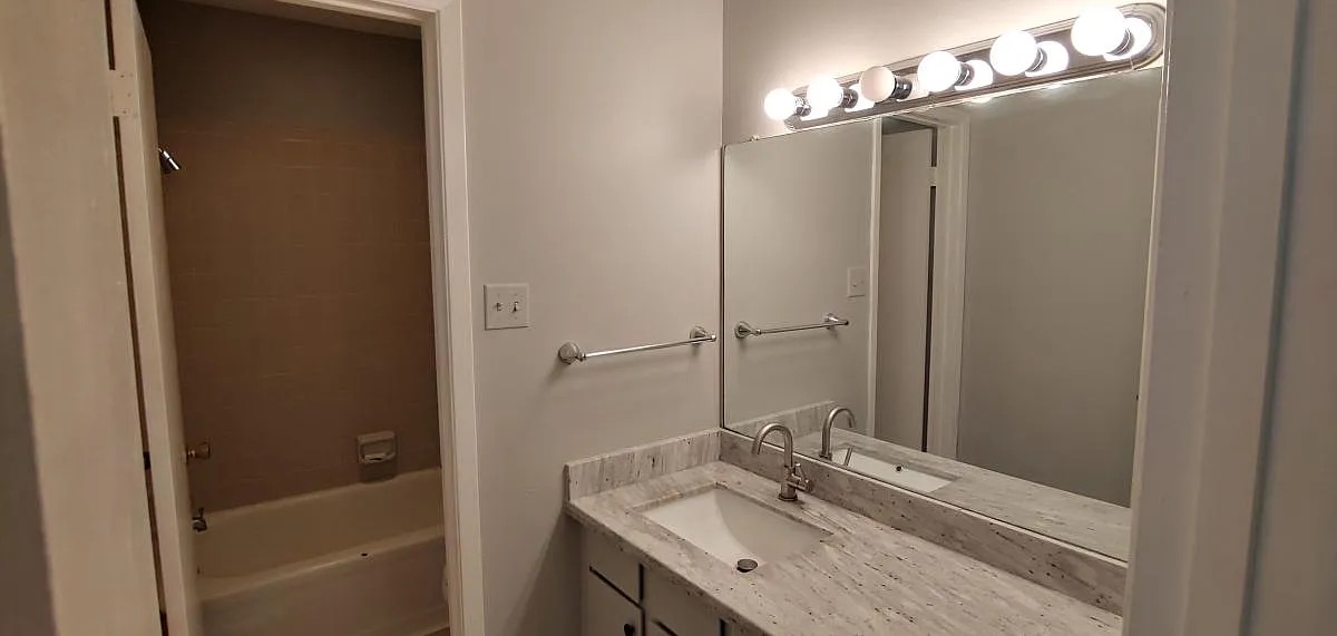 4441 Old College Road, Unit 5204 Bryan, TX 77801 - Photo 9 of 14 a bathroom with a tub sink vanity and a mirror