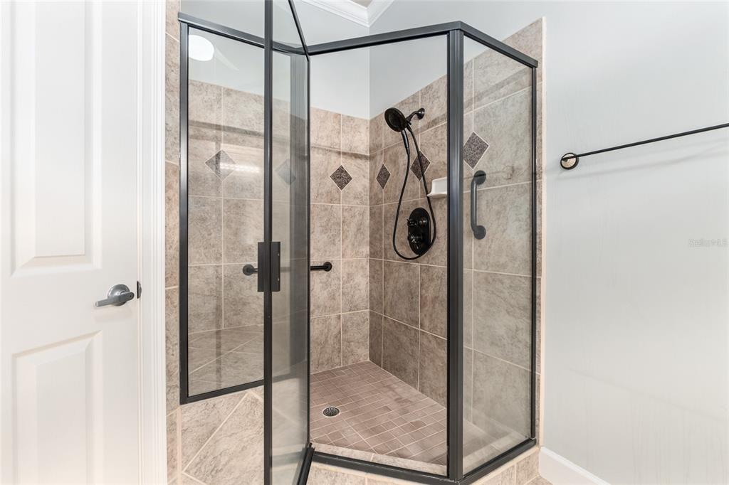 10614 Southwest 15th Lane Gainesville, FL 32607 - Photo 38 of 85 a bathroom with a glass shower door and mirror