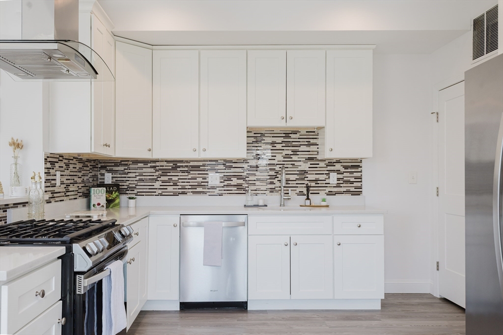 92-94 George Street, Unit 202 Boston, MA 02119 - Photo 12 of 42 a kitchen with white cabinets and appliances