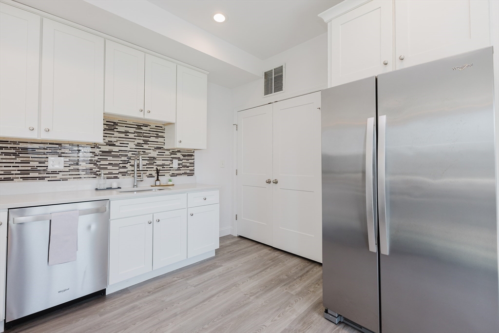 92-94 George Street, Unit 202 Boston, MA 02119 - Photo 13 of 42 a kitchen with white cabinets and white appliances
