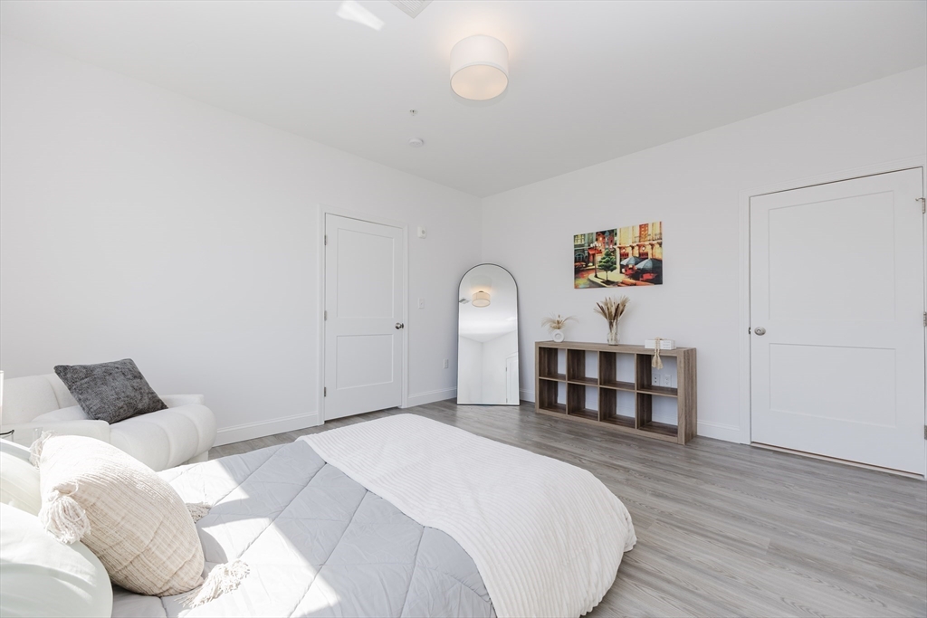 92-94 George Street, Unit 202 Boston, MA 02119 - Photo 23 of 42 a bedroom with a bed and wooden floor