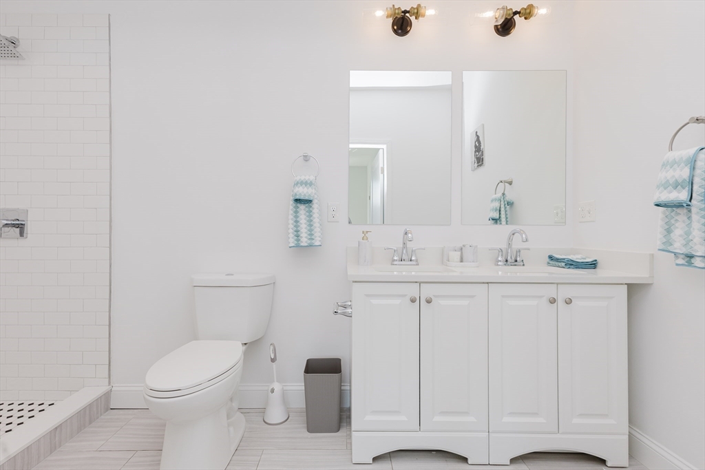 92-94 George Street, Unit 202 Boston, MA 02119 - Photo 27 of 42 a bathroom with a toilet a sink a vanity and mirror