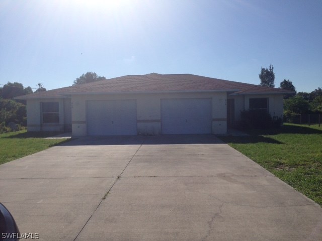 914 Alabama Road South Lehigh Acres, FL 33974 - Photo 1 of 6 front view of a house with a yard