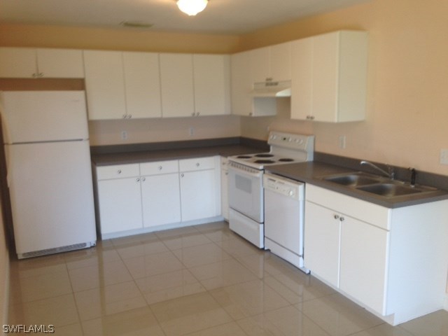 914 Alabama Road South Lehigh Acres, FL 33974 - Photo 2 of 6 a kitchen with granite countertop white cabinets and white appliances