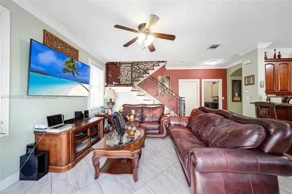 a living room with furniture ceiling fan and a rug
