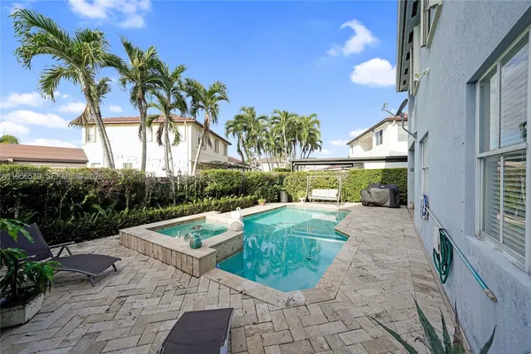 a view of a house with swimming pool and sitting area