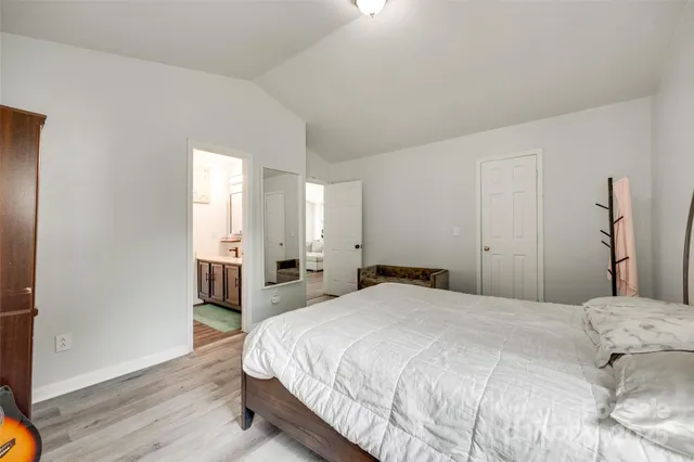 a spacious bedroom with a bed and a wooden floor