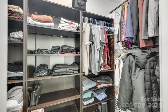 a view of walk in closet with clothes and shoes