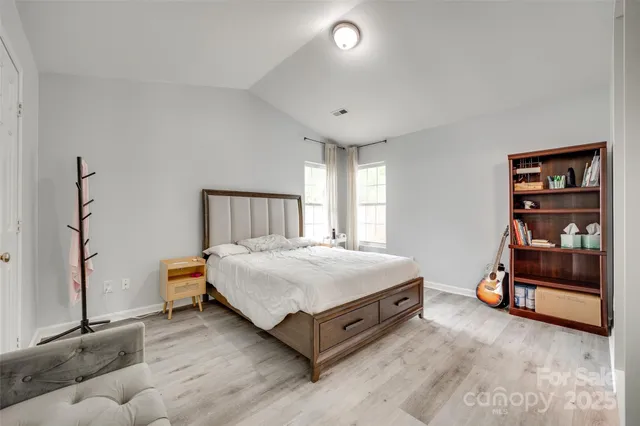 a spacious bedroom with a bed and a cabinet