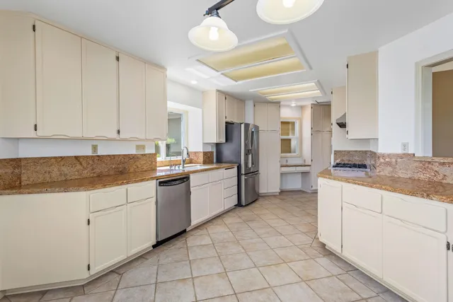 a large kitchen with cabinets and stainless steel appliances