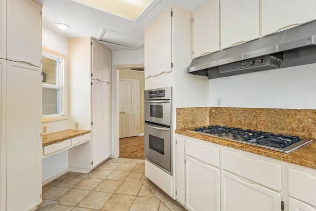 a kitchen with white cabinets and appliances