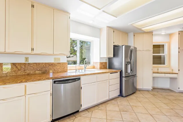 a kitchen with a refrigerator sink and cabinets