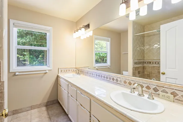a spacious bathroom with a sink double vanity and a mirror
