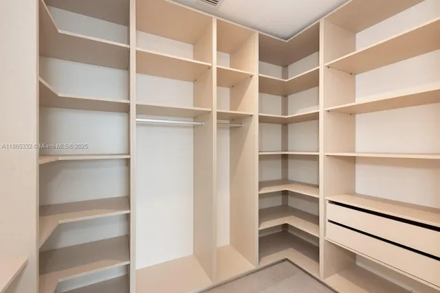 a view of walk in closet with empty racks