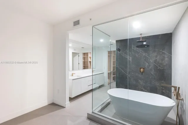 a bathroom with a white tub shower and toilet