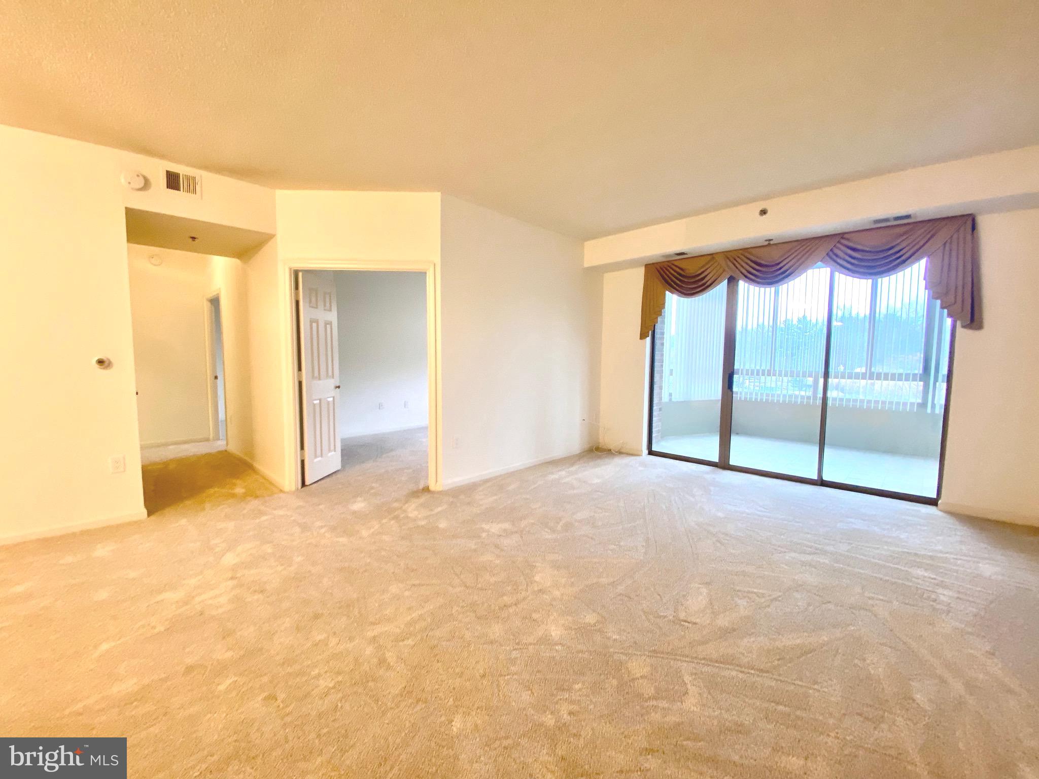 3200 North Leisure World Boulevard, Unit 115 Silver Spring, MD 20906 - Photo 1 of 28 a view of an empty room with a sliding door