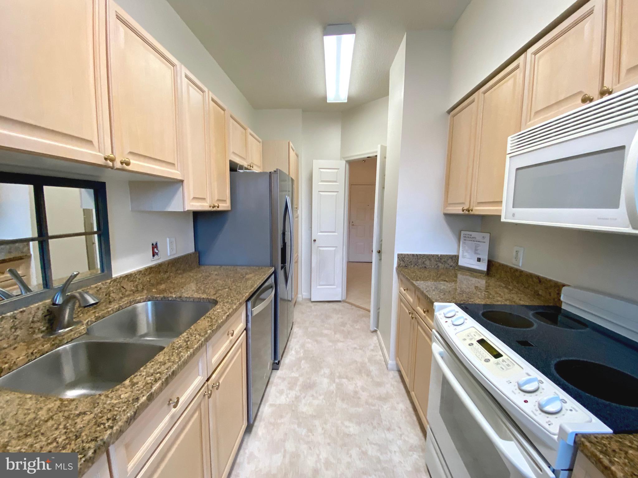 3200 North Leisure World Boulevard, Unit 115 Silver Spring, MD 20906 - Photo 6 of 28 a kitchen with stainless steel appliances granite countertop a sink stove and refrigerator