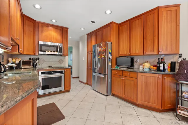 a kitchen with stainless steel appliances granite countertop a refrigerator and a stove top oven