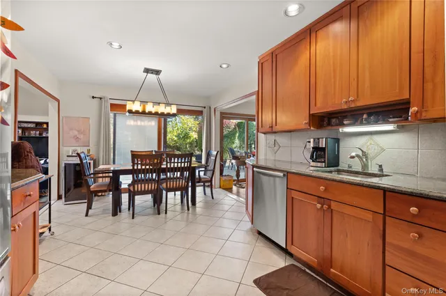 a kitchen with stainless steel appliances granite countertop table chairs sink and cabinets