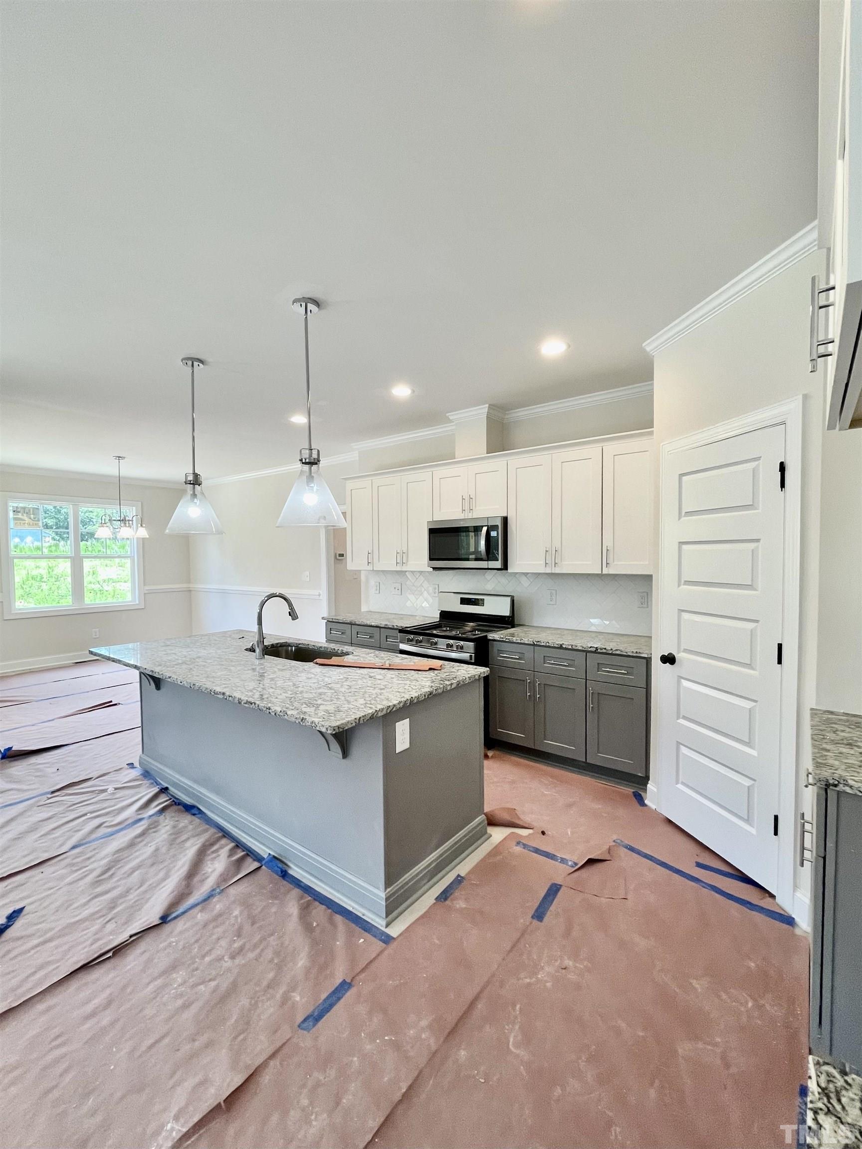 1428 Old Watkins Road Raleigh, NC 27616 - Photo 12 of 36 a large kitchen with kitchen island a sink stainless steel appliances and cabinets