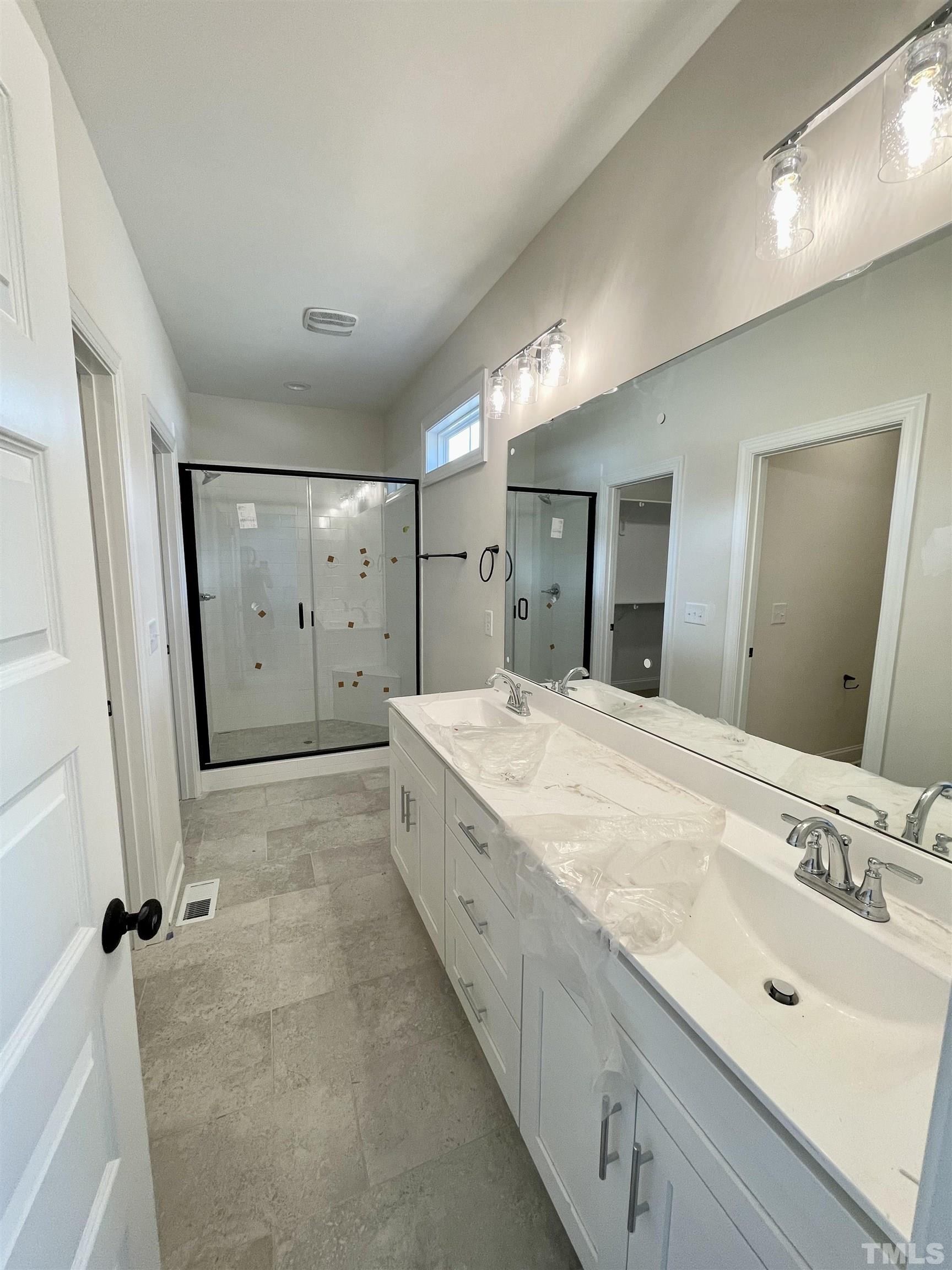 1428 Old Watkins Road Raleigh, NC 27616 - Photo 16 of 36 a spacious bathroom with a granite countertop sink a mirror and a shower