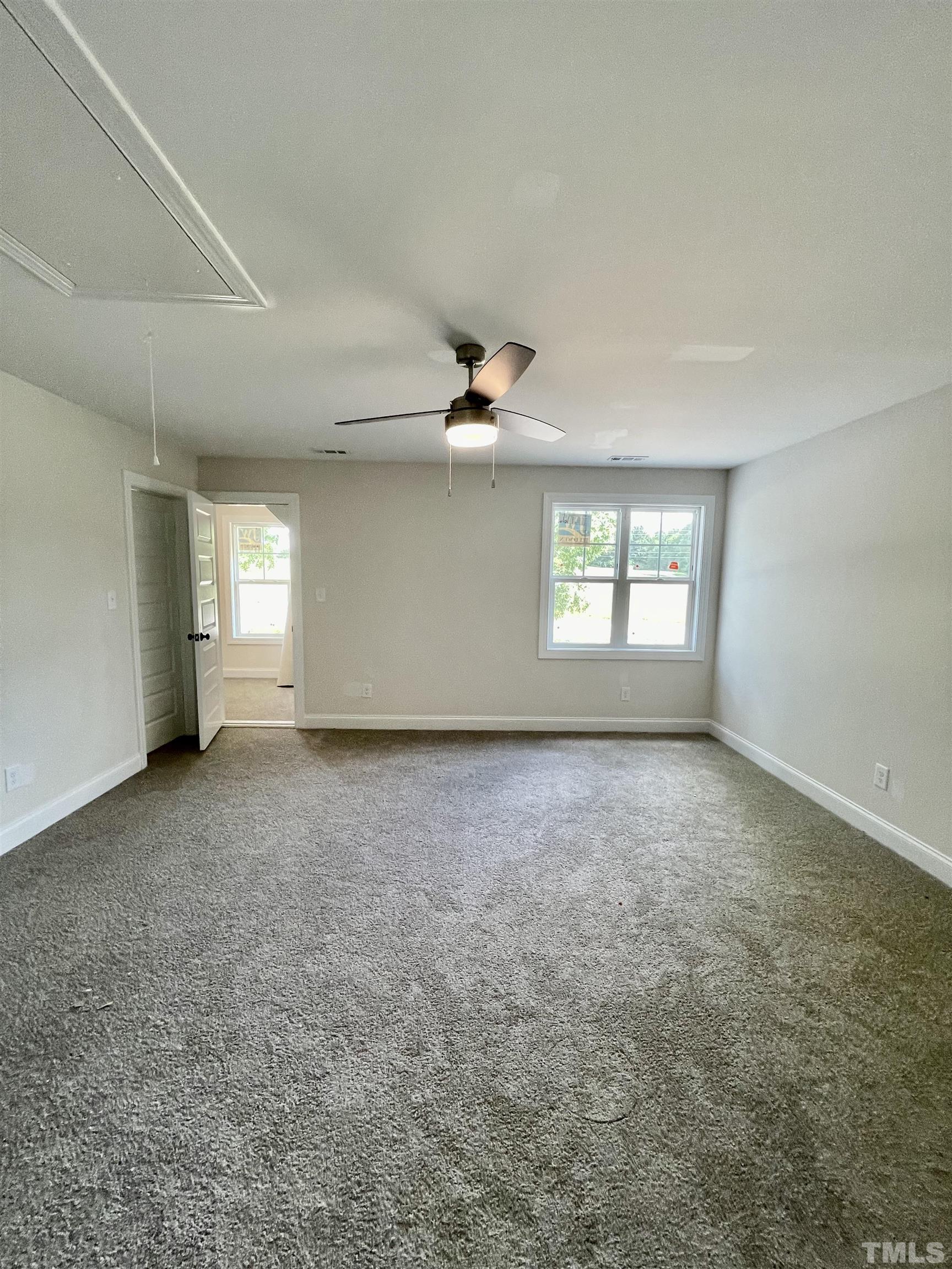1428 Old Watkins Road Raleigh, NC 27616 - Photo 30 of 36 an empty room with windows and ceiling fan