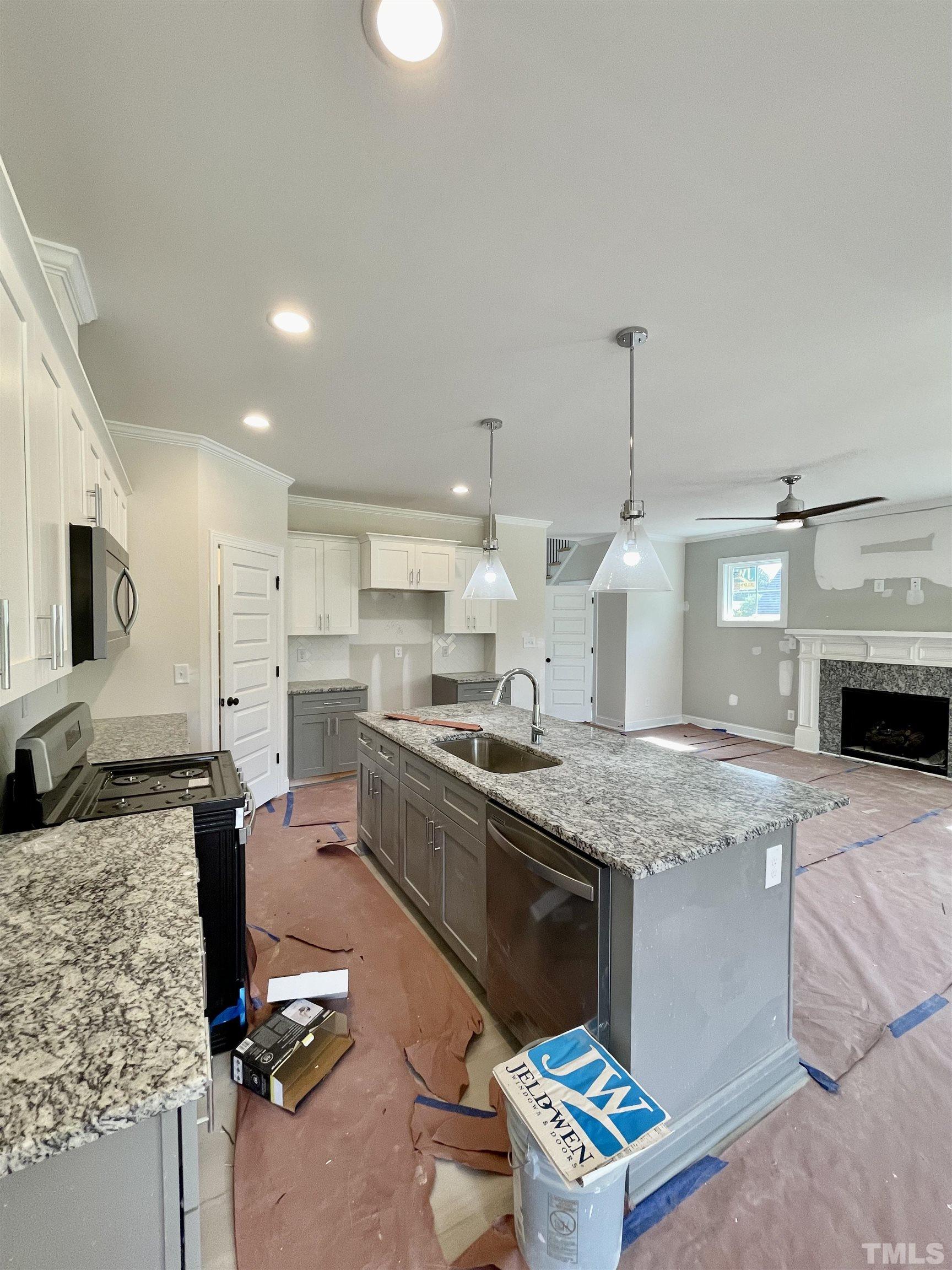 1428 Old Watkins Road Raleigh, NC 27616 - Photo 9 of 36 a kitchen with kitchen island granite countertop a sink stove and refrigerator