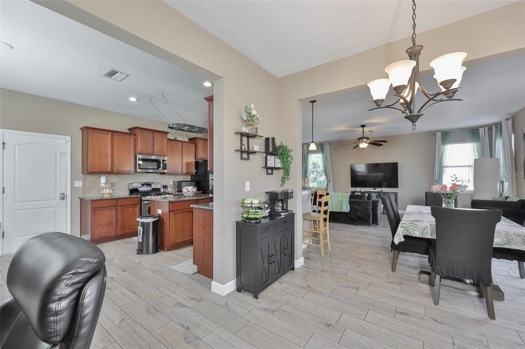 5779 Aaron Court Sarasota, FL 34232 - Photo 11 of 39 a view of a dining room with furniture a kitchen and chandelier