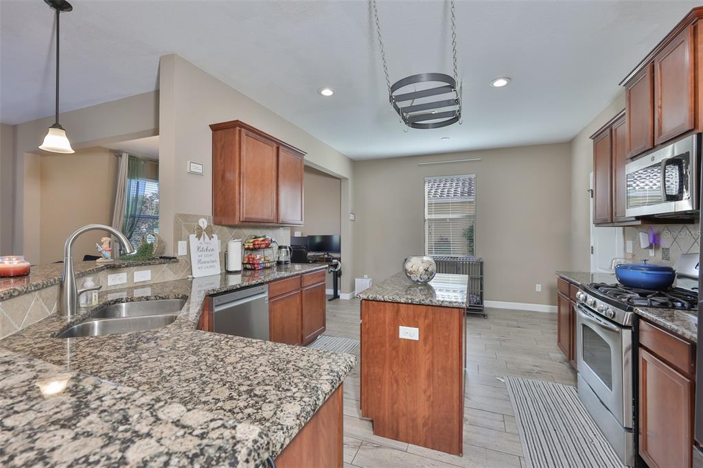 5779 Aaron Court Sarasota, FL 34232 - Photo 5 of 39 a kitchen with stainless steel appliances granite countertop a sink stove and refrigerator