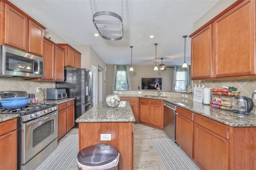 5779 Aaron Court Sarasota, FL 34232 - Photo 6 of 39 a kitchen with stainless steel appliances granite countertop a sink a stove a refrigerator cabinets and a window