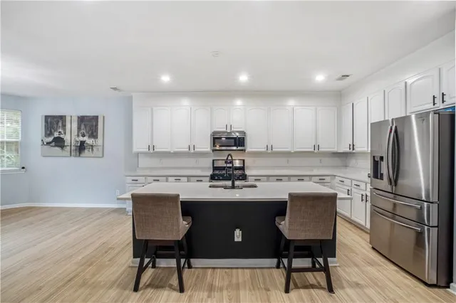 a large kitchen with stainless steel appliances lots of counter space and wooden floor