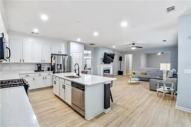 a kitchen with a sink dishwasher and a stove with wooden floor