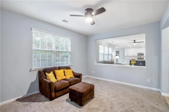 a living room with furniture and a ceiling fan