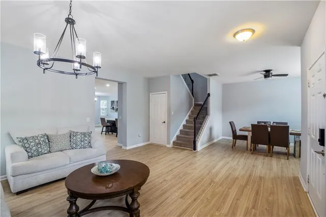 a kitchen with kitchen island a dining table chairs stainless steel appliances and cabinets