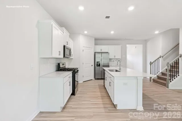 a large kitchen with stainless steel appliances lots of counter top space and cabinets