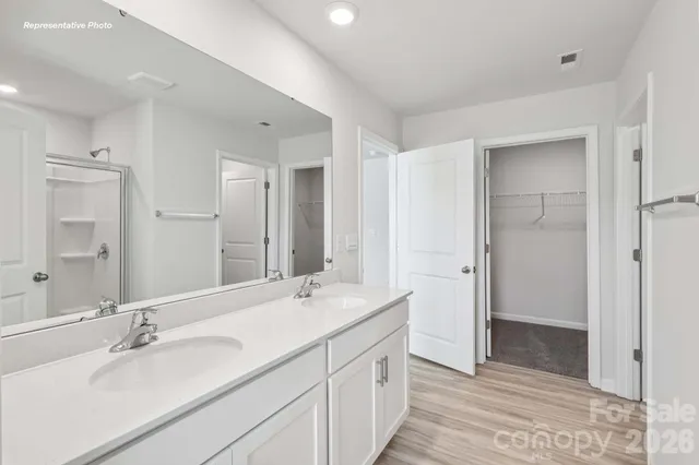 a bathroom with a double vanity sink mirror and shower