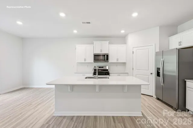 a kitchen with stainless steel appliances a refrigerator sink and microwave