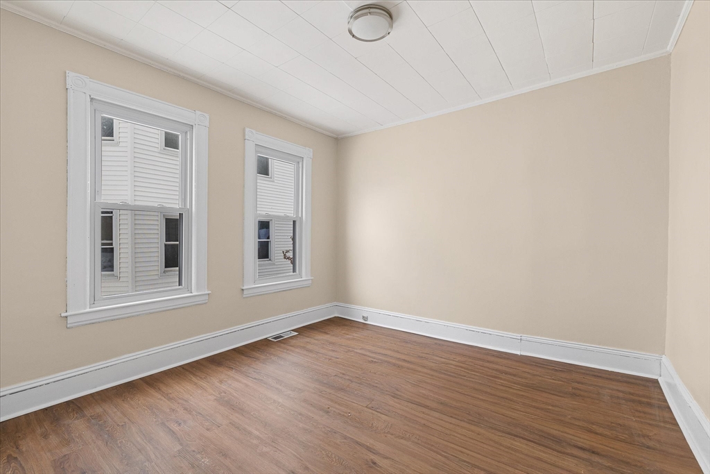 189-191 Northampton Avenue Springfield, MA 01109 - Photo 8 of 39 a view of an empty room with wooden floor and a window
