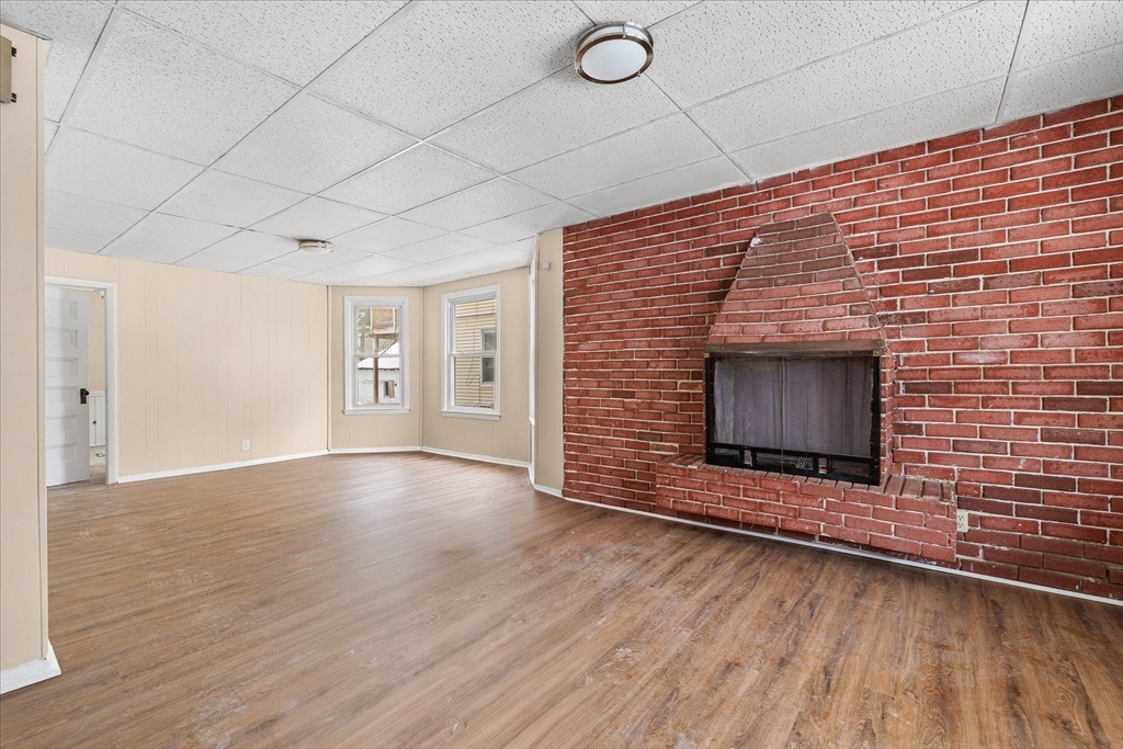 189-191 Northampton Avenue Springfield, MA 01109 - Photo 9 of 39 a view of an empty room with wooden floor and fireplace