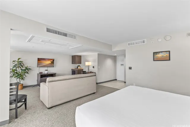 a living room with furniture and a potted plant