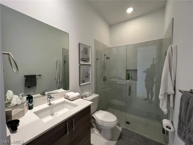 a bathroom with a sink toilet a mirror and shower