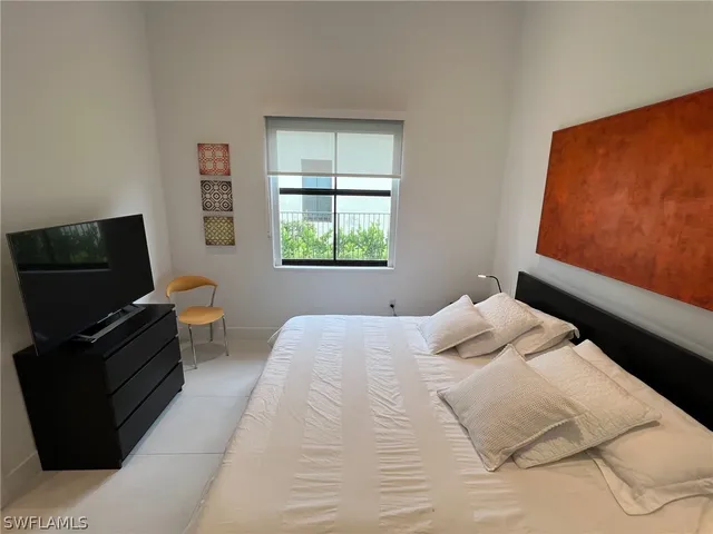 a bedroom with a bed and flat screen tv