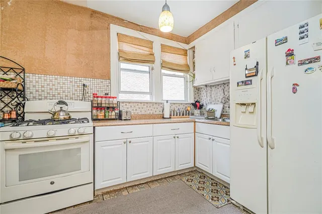 a kitchen with white cabinets and white appliances