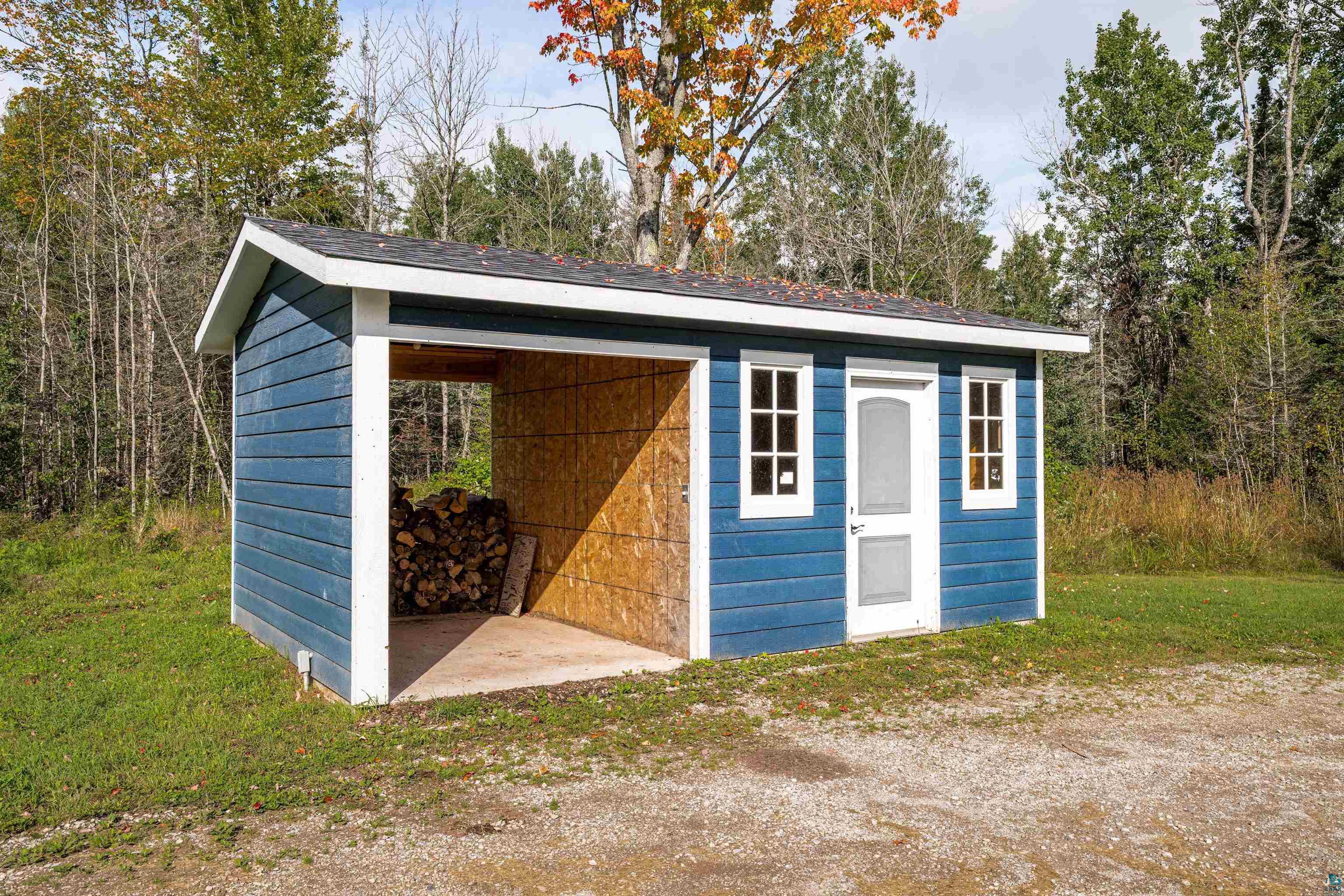3126 Beyer Road Duluth, MN 55804 - Photo 7 of 23 Utility shed with blue horizontal siding, white trim, and an asphalt shingle roof