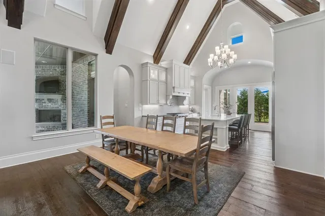 a dining room with furniture a chandelier and wooden floor