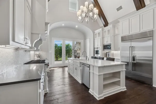 a kitchen with kitchen island granite countertop lots of counter top space and stainless steel appliances